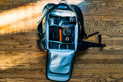 单反相机在木地板背包中的平面摄影
